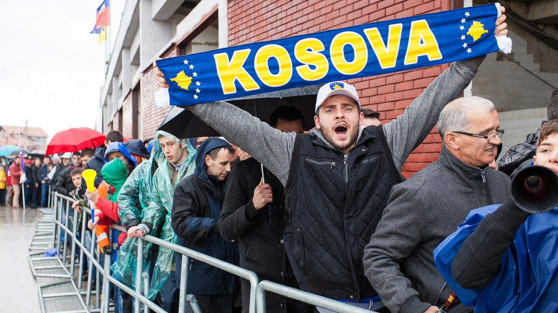 A fan cheering for Kosovo while waiting to enter the stadium